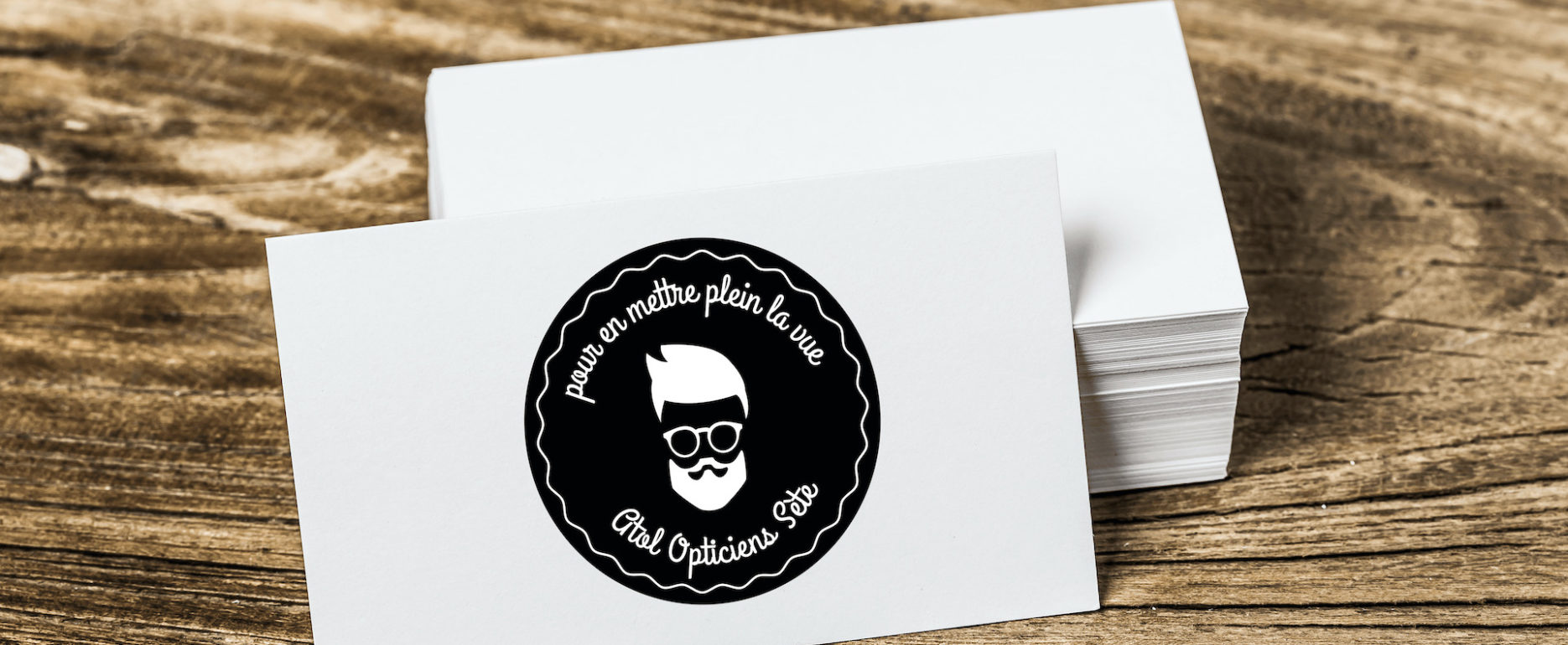 Tas de stickers noirs posé sur une planche en bois