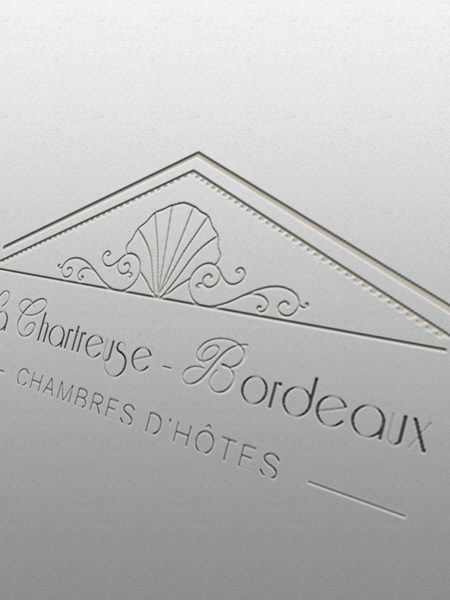 Logo La Chartreuse Bordeaux gravé sur un mur blanc