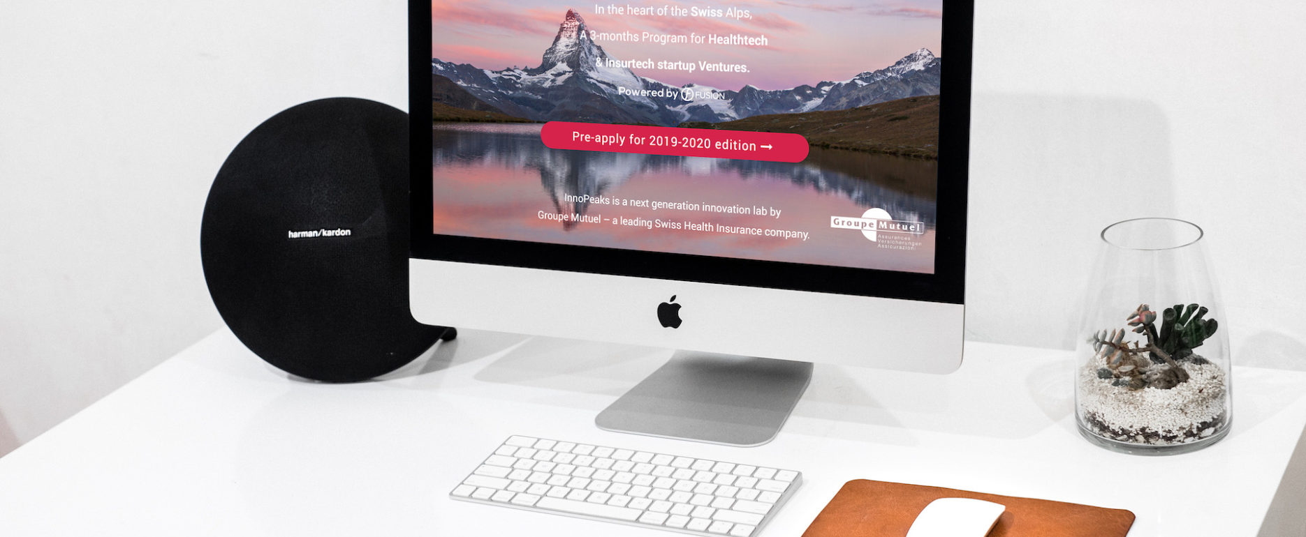 iMac posé sur un bureau allumé avec la page internet du site Innopeaks