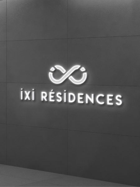Logo Ixi Résidences lumineux sur un mur gris