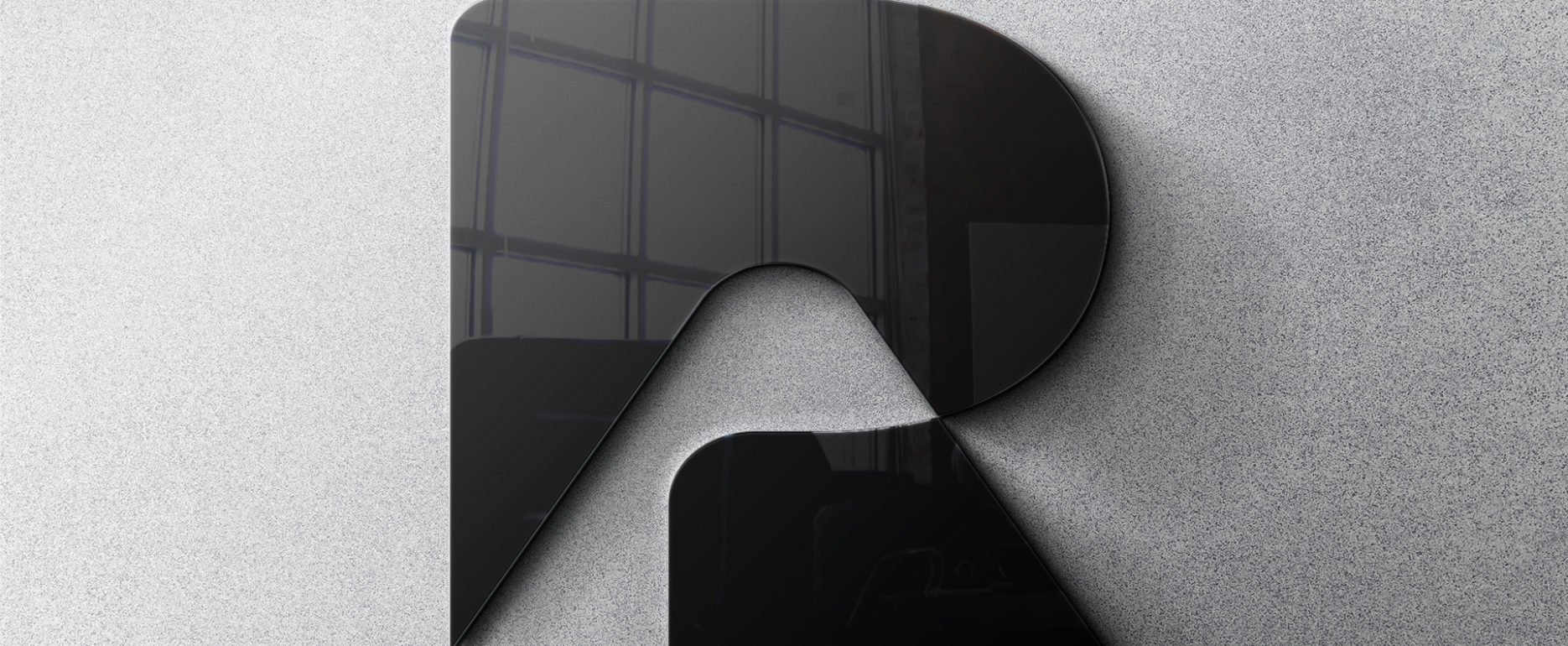 Logo PR noir brillant sur un mur gris clair